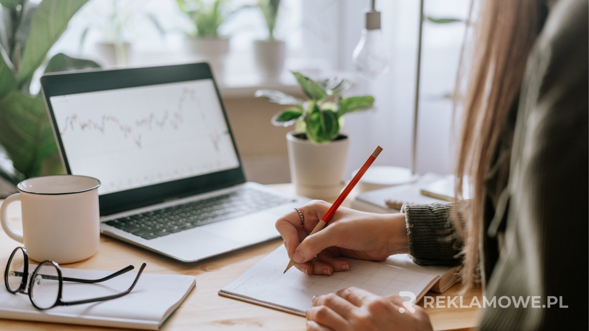 Notatnik reklamowy na biurku obok laptopa